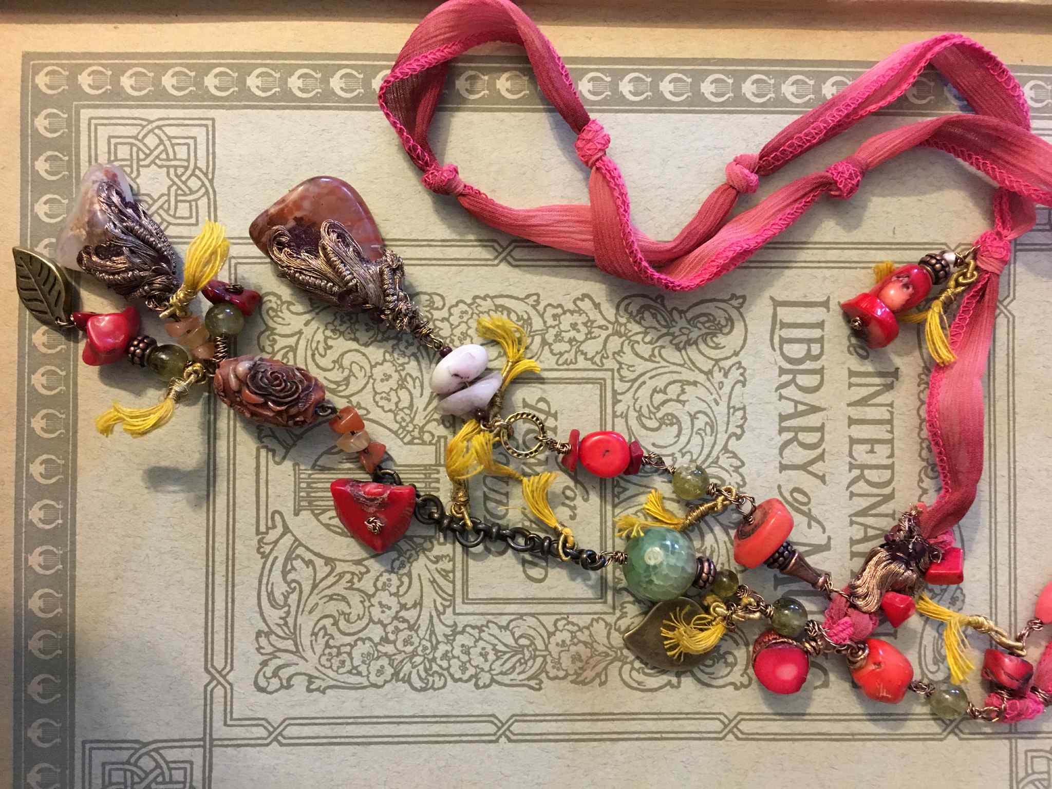 “Opulent Caravan” – Bohemian Silk Ribbon Necklace with Coral, Agate, Carved Rose, and Bronze Charms